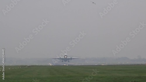 wide shot of heay long haul passenger jet taking off take off at generic airport low cloud level ceiling foggy cloudy weather photo