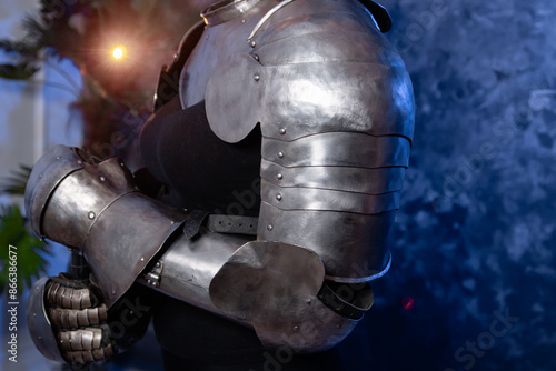 Close-up of armor, knight's steel hands on an abstract background.