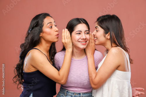 Three Glamorous Ladies Are Smiling While Whispering In Each Other's Ears