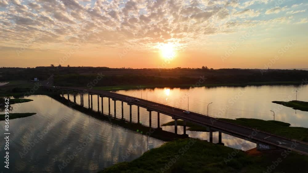 Aerial view of cinematic sunset on the Paraná River. bridge over the Arroyo Mártires in Posadas, Misiones, Argentina. Sustainable solar energy. Aerial view of cinematic sunset on the Paraná River. bridge over the Arroyo Mártires in Posadas, Misiones, Argentina. Sustainable solar energy.