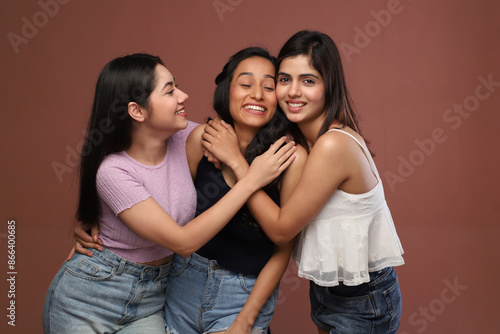 Three Trendy Women Are Smiling And Hugging Each Other