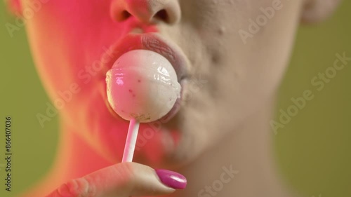 woman licking popsicle with seduction, mouth close-up shot on green background photo