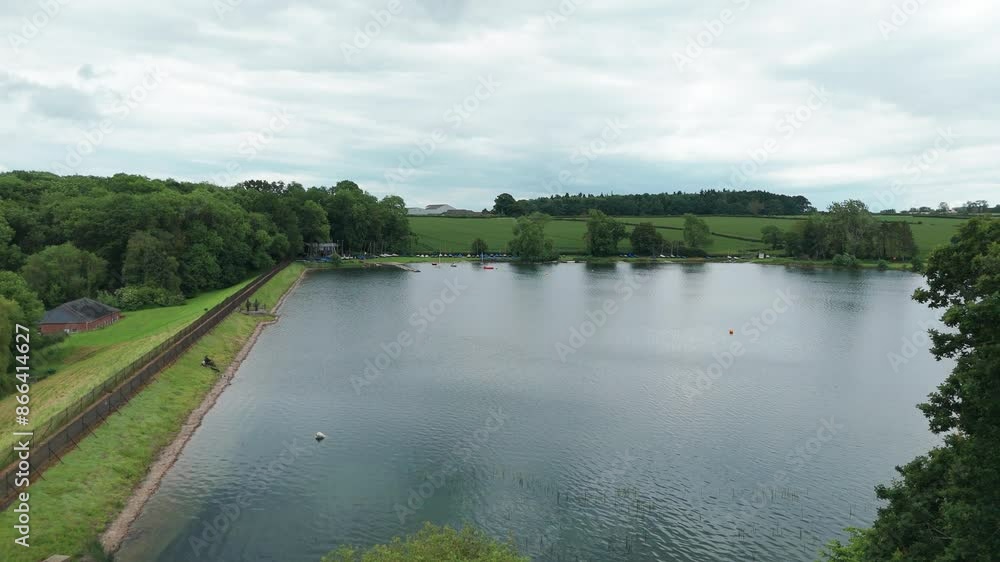 A calm time near Kettering Reservoir: surrounded by bright green trees a reservoir attracts people to relax A calm time near Kettering Reservoir: surrounded by bright green trees a reservoir attracts people to relax