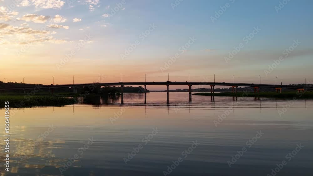 Drone flight over water surface in Paraná River. Arroyo Mártires Bridge. Cinematic beautiful sunset. Posadas, Misiones, Argentina. Drone flight over water surface in Paraná River. Arroyo Mártires Bridge. Cinematic beautiful sunset. Posadas, Misiones, Argentina.