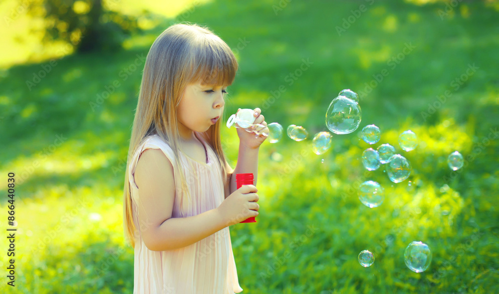 Little girl child blowing soap bubbles, kid walking outdoors on summer day Little girl child blowing soap bubbles, kid walking outdoors on summer day