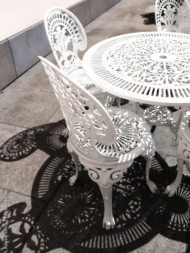 Obraz premium openwork white metal tables and chairs 