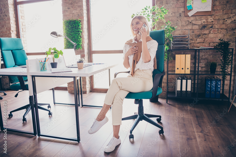 Full size photo of pretty young girl talk phone call wear trendy outfit modern workplace success business owner office Full size photo of pretty young girl talk phone call wear trendy outfit modern workplace success business owner office