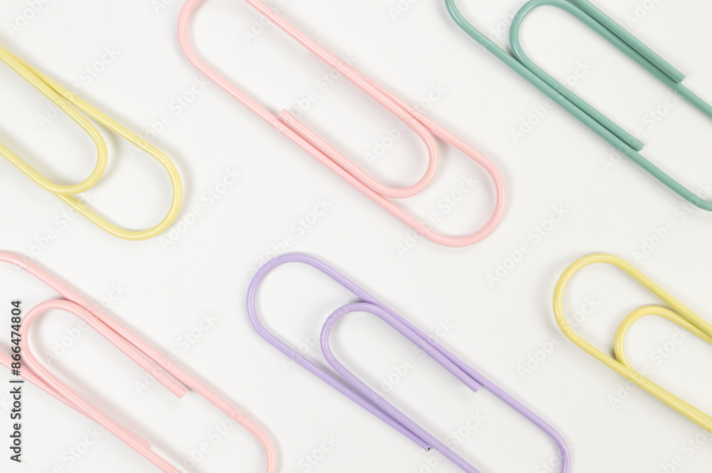 Top view of colorful paperclips on white background. School, office wallpaper. Flat lay, copy space. Top view of colorful paperclips on white background. School, office wallpaper. Flat lay, copy space.