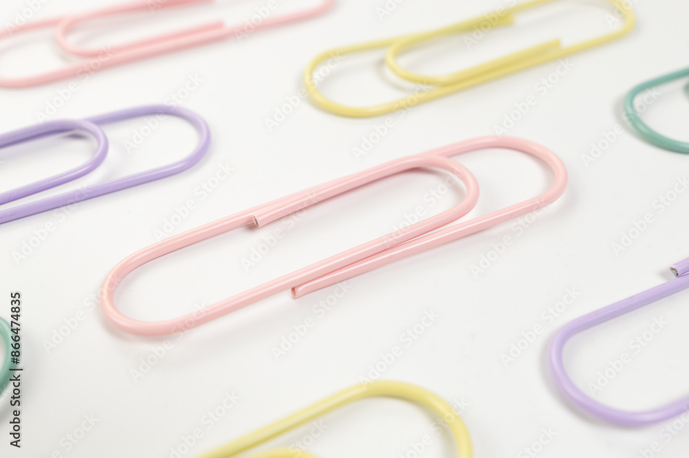 Top view of colorful paperclips on white background. School, office wallpaper. Flat lay, copy space. Top view of colorful paperclips on white background. School, office wallpaper. Flat lay, copy space.