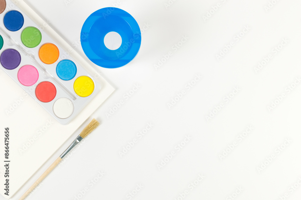Top view of watercolor, paint brush, paper and water pot on white background. Painting, art, copy space, flat lay. Top view of watercolor, paint brush, paper and water pot on white background. Painting, art, copy space, flat lay.