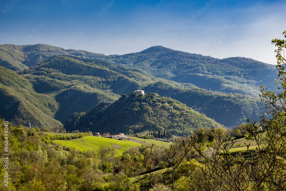 Fototapeta premium A view of Mount Antuni on Lake Turano, near the village of Castel di Tora, Rieti, Lazio, Italy. The uninhabited village stands in the center of the lake, surrounded by green mountains.