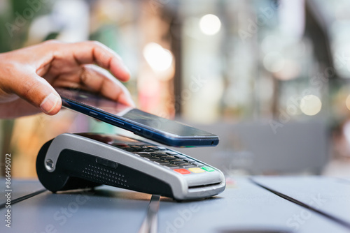 man paying contactless with mobile phone in restaurant. photo