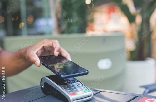 man paying contactless with mobile phone in restaurant.