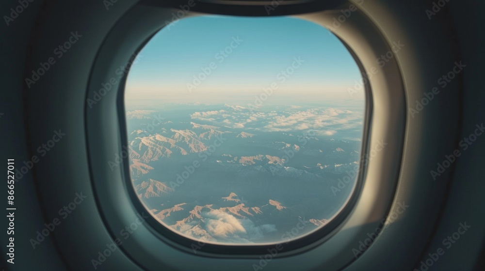 A close-up photograph taken from an airplane window, revealing a breathtaking view of mountain ranges stretching out below the clouds A close-up photograph taken from an airplane window, revealing a breathtaking view of mountain ranges stretching out below the clouds