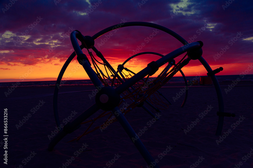 A beautiful summer sunset at the sea with kids playground constructions. Colorful evening at the beach. A beautiful summer sunset at the sea with kids playground constructions. Colorful evening at the beach.
