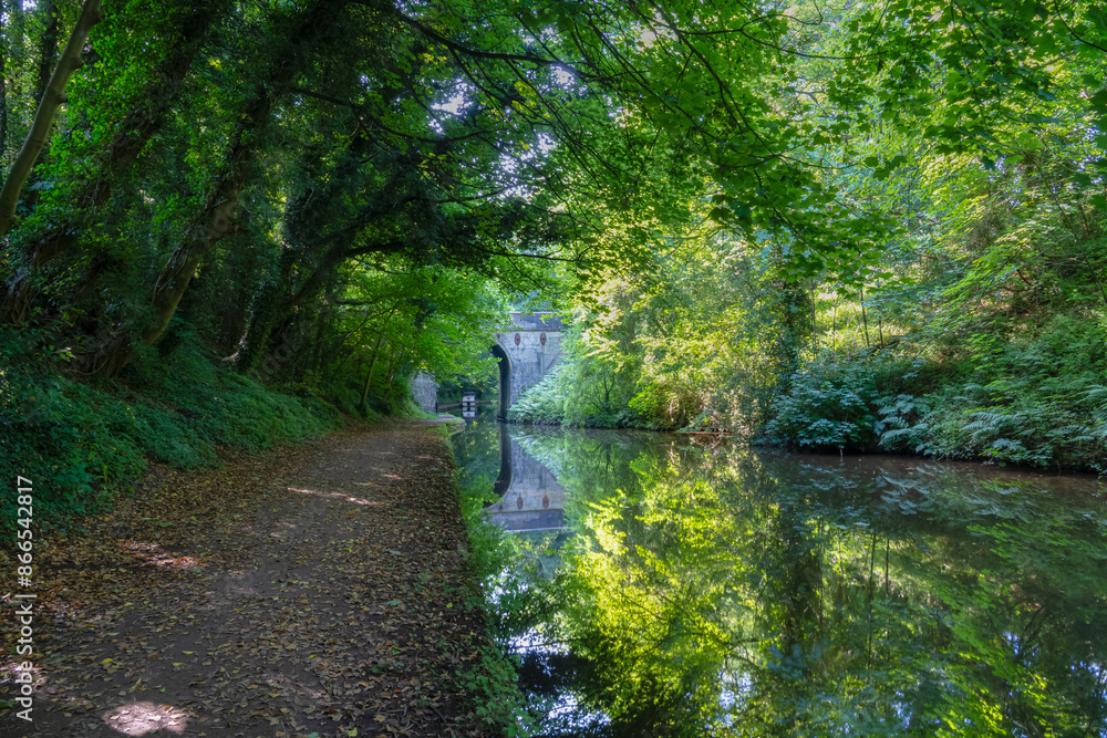 Canal towpath with a bridge and perfect reflections Canal towpath with a bridge and perfect reflections