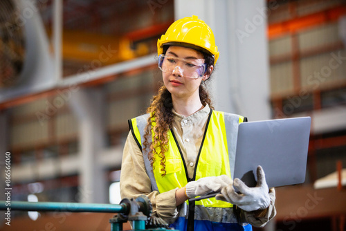 engineer female using laptop working in manufacturing factory. woman worker technician metalwork automated mechanical energy project.