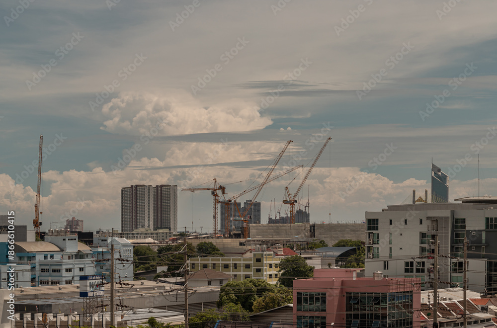 View of Construction of tall buildings with a crane and background of Dramatic sky in the city of Bangkok. Tower crane, Construction cranes, Construction and urban development concepts, Space for text View of Construction of tall buildings with a crane and background of Dramatic sky in the city of Bangkok. Tower crane, Construction cranes, Construction and urban development concepts, Space for text