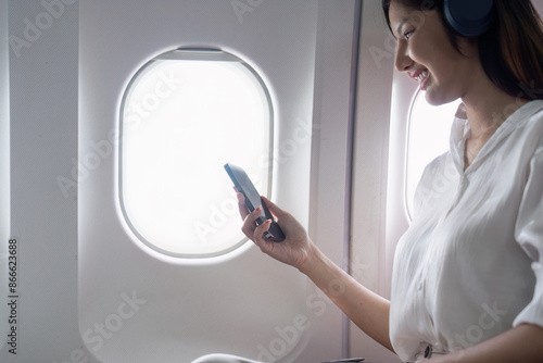 Fotografia Modern Technology in Flight Travel, Passenger Using Smartphone on Airplane