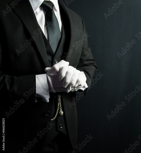 Butler or Hotel Concierge in Dark Formal Attire and White Gloves Standing at Attention. White Glove Service and Professional Courtesy.