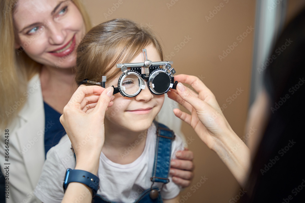Cute girl with her mother at an appointment with ophthalmologist Cute girl with her mother at an appointment with ophthalmologist