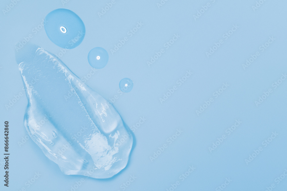 Gel smears and drops of cosmetic texture on blue background with space for text Gel smears and drops of cosmetic texture on blue background with space for text