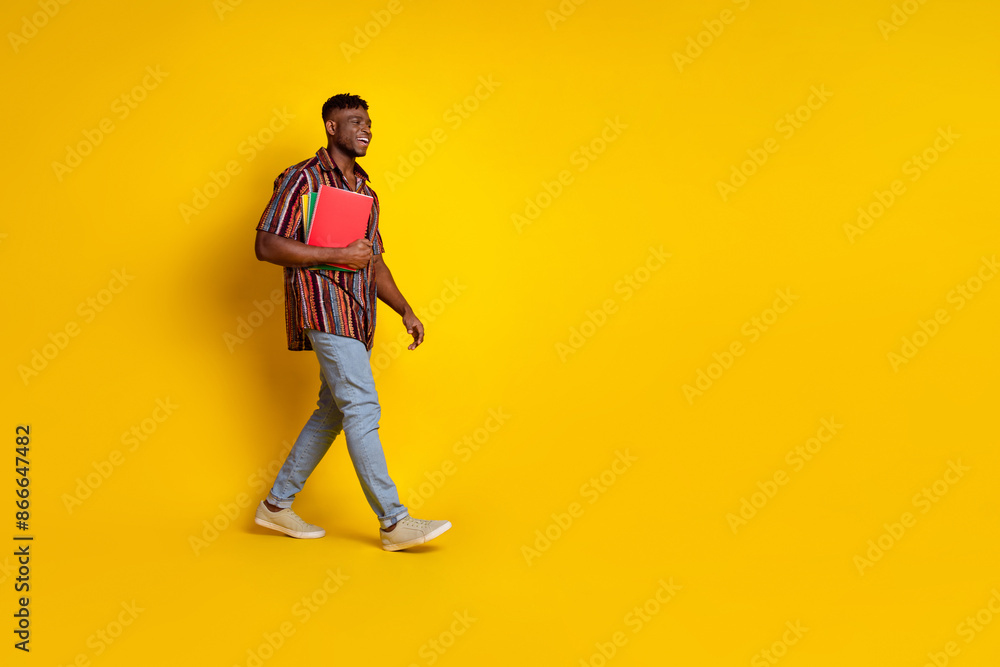 Full size profile photo of nice young man walk empty space wear shirt isolated on yellow color background Full size profile photo of nice young man walk empty space wear shirt isolated on yellow color background