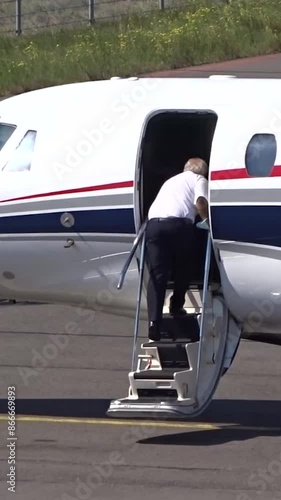 Executive Jet with Pilot boarding the airplane at Small Airport (Business   private jet   corporate jet) photo