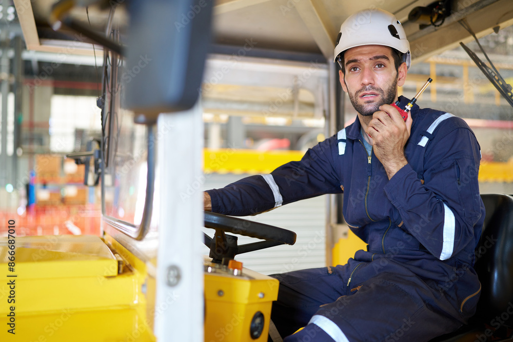 Engineer or worker talking on walkie talkie and driving a car in the factory Engineer or worker talking on walkie talkie and driving a car in the factory