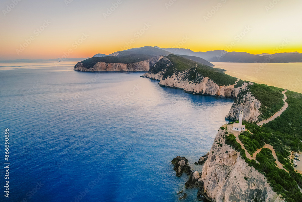 Fototapeta premium Lighthouse on the cliff. Seascape of Cape Lefkatas with old lighthouse on Lefkada island, Greece. Beautiful views of azure sea water and nature with cliffs