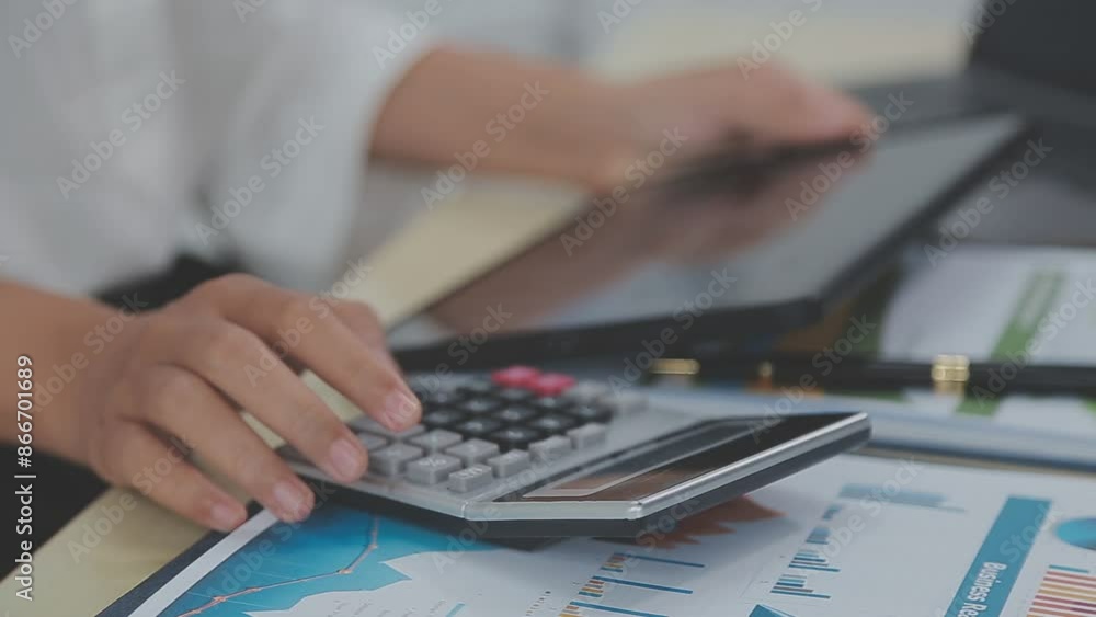 Asian Business woman using calculator and laptop for doing math finance on an office desk, tax, report, accounting, statistics, and analytical research concept Asian Business woman using calculator and laptop for doing math finance on an office desk, tax, report, accounting, statistics, and analytical research concept
