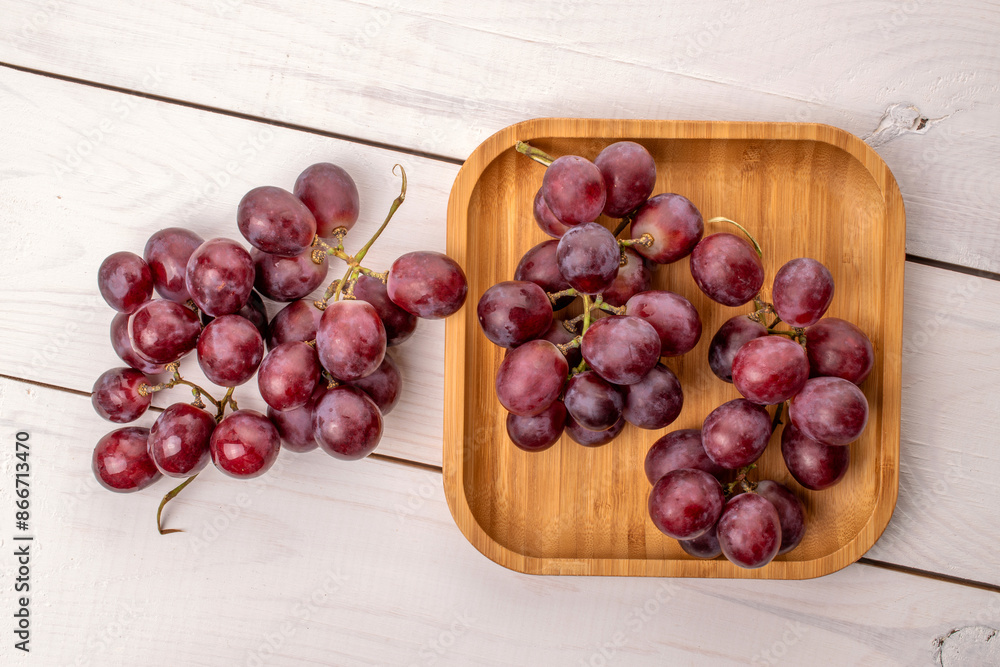 Ripe grapes with bamboo plate on wooden table, macro, top view. Ripe grapes with bamboo plate on wooden table, macro, top view.