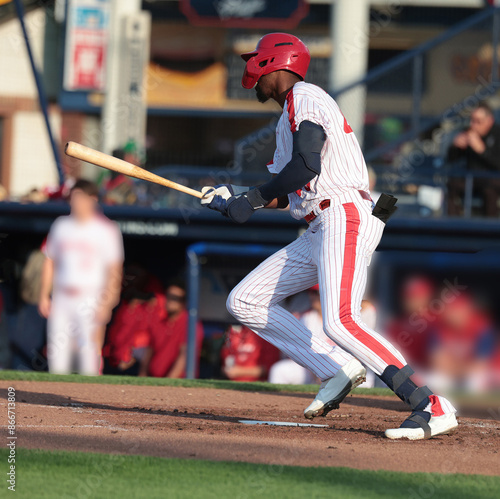 Photography baseball player swinging his bat and running