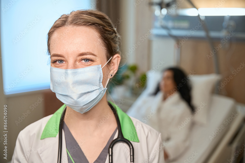 Clinic employee wearing a protective mask in a hospital ward Clinic employee wearing a protective mask in a hospital ward