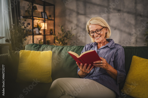 Mature senior woman sit in the living room and read a book
