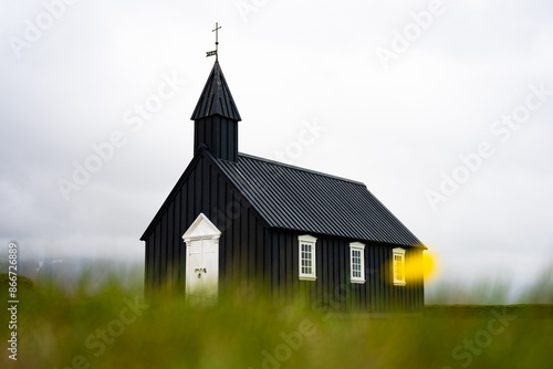 Obraz na płótnie Stunning view of the black church of Budir with defocused grass in the foreground. Búðakirkja is a small wooden church located on the south side of Snæfellsnes, Iceland.. w salonie