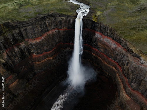 Obraz na płótnie View from above, stunning aerial view of the Hengifoss Waterfall. Hengifoss, is eye-catching due to the striking red clay and black basalt patterns of the cliff face. Fljótsdalshreppur, East Iceland. w salonie