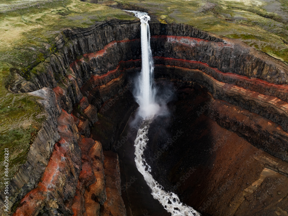 View from above, stunning aerial view of the Hengifoss Waterfall. Hengifoss, is eye-catching due to the striking red clay and black basalt patterns of the cliff face. Fljótsdalshreppur, East Iceland.