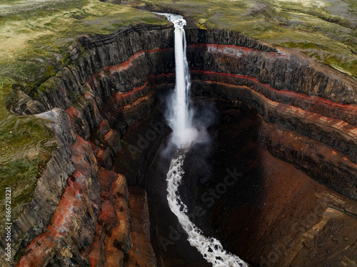 Obraz na płótnie View from above, stunning aerial view of the Hengifoss Waterfall. Hengifoss, is eye-catching due to the striking red clay and black basalt patterns of the cliff face. Fljótsdalshreppur, East Iceland. w salonie