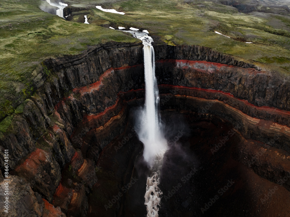 View from above, stunning aerial view of the Hengifoss Waterfall. Hengifoss, is eye-catching due to the striking red clay and black basalt patterns of the cliff face. Fljótsdalshreppur, East Iceland.