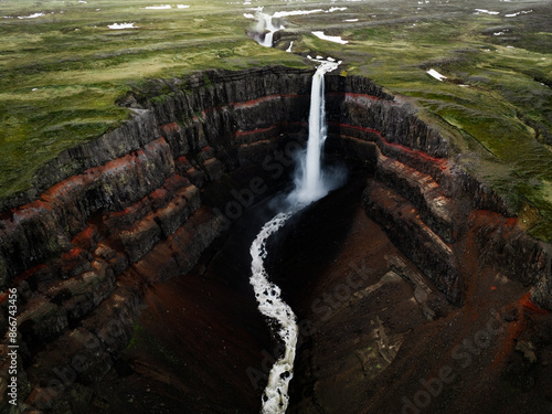 Obraz na płótnie View from above, stunning aerial view of the Hengifoss Waterfall. Hengifoss, is eye-catching due to the striking red clay and black basalt patterns of the cliff face. Fljótsdalshreppur, East Iceland. w salonie