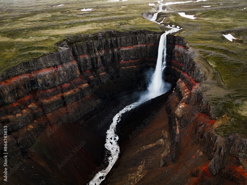View from above, stunning aerial view of the Hengifoss Waterfall. Hengifoss, is eye-catching due to the striking red clay and black basalt patterns of the cliff face. Fljótsdalshreppur, East Iceland.