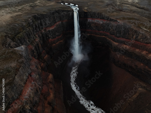 Obraz na płótnie View from above, stunning aerial view of the Hengifoss Waterfall. Hengifoss, is eye-catching due to the striking red clay and black basalt patterns of the cliff face. Fljótsdalshreppur, East Iceland. w salonie