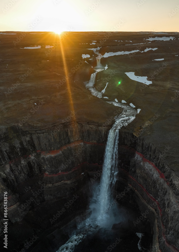 View from above, stunning aerial view of the Hengifoss Waterfall. Hengifoss, is eye-catching due to the striking red clay and black basalt patterns of the cliff face. Fljótsdalshreppur, East Iceland.