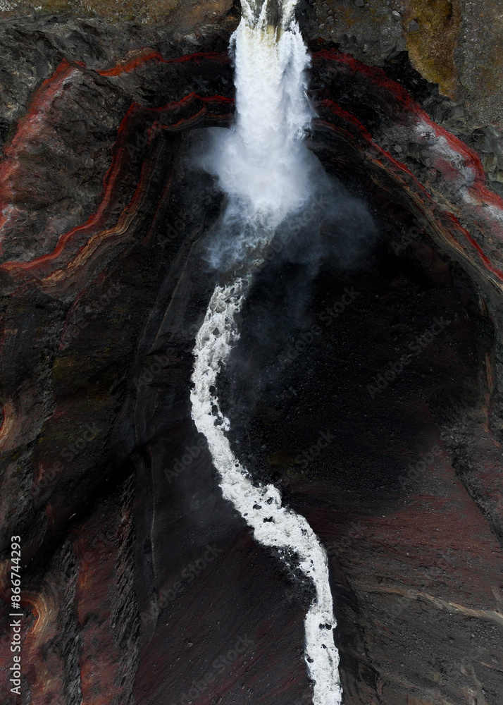View from above, stunning aerial view of the Hengifoss Waterfall. Hengifoss, is eye-catching due to the striking red clay and black basalt patterns of the cliff face. Fljótsdalshreppur, East Iceland.