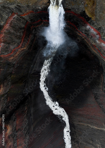 View from above, stunning aerial view of the Hengifoss Waterfall. Hengifoss, is eye-catching due to the striking red clay and black basalt patterns of the cliff face. Fljótsdalshreppur, East Iceland.