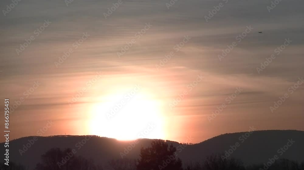 Pink and yellow sky with clouds, yellow sunlight during rising sun and plane in flight over dark horizon with forests and cross in Silesian Beskid mountains in Poland on autumn time - real time. Pink and yellow sky with clouds, yellow sunlight during rising sun and plane in flight over dark horizon with forests and cross in Silesian Beskid mountains in Poland on autumn time - real time.