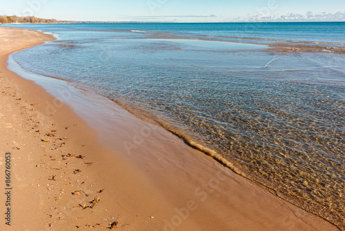 Obraz na plátně The calm water of Lake Michigan recede from the shoreline beach at Harrington Be