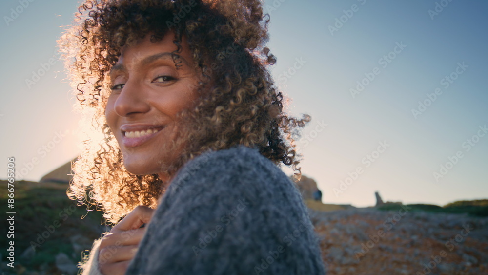 Curly model posing sunny nature portrait. Happy wavy hair woman smiling camera Curly model posing sunny nature portrait. Happy wavy hair woman smiling camera