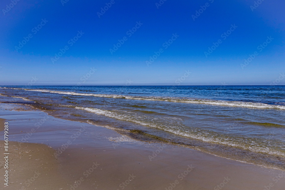 Kleine Wellen der Nordsee. Der Sandstrand von Ameland im Sommer. Kleine Wellen der Nordsee. Der Sandstrand von Ameland im Sommer.